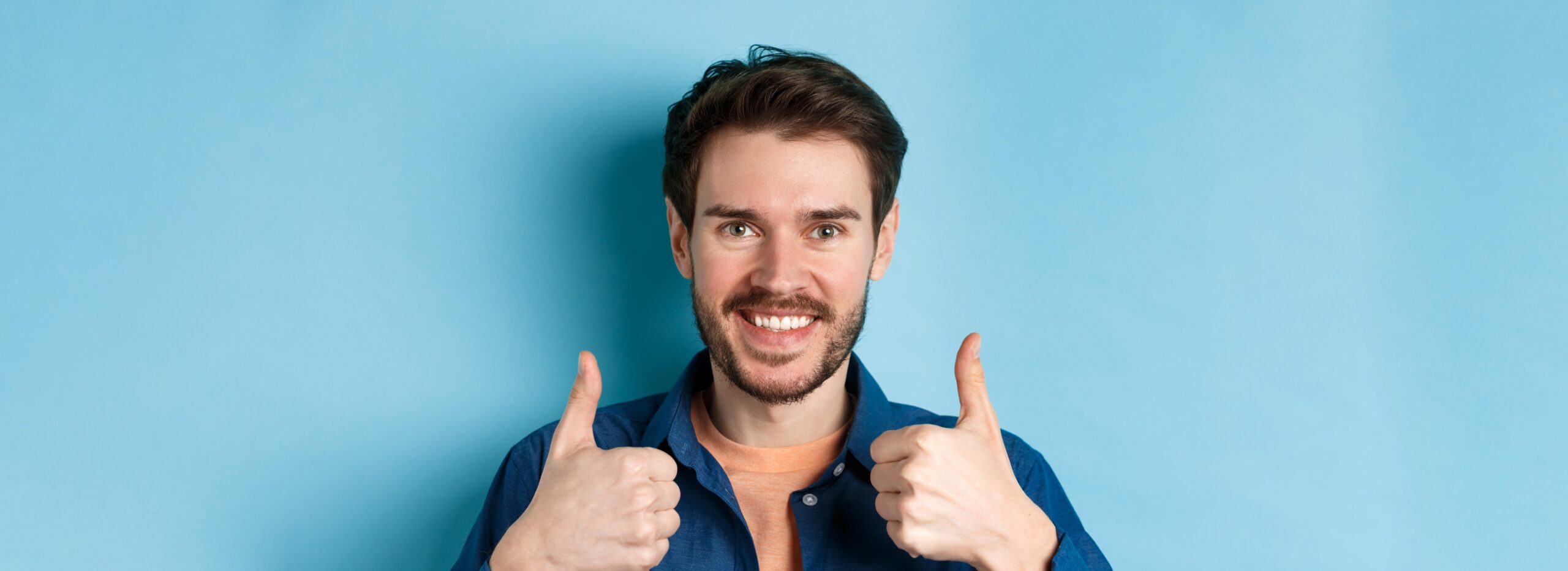 closeup smiling goodlooking man showing thumbs up praising good job recommending company standing (1)